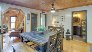 A wooden dining table with chairs, a ceiling fan, and a staircase leading to another room. - Prime Views! Above & Beyond Pigeon Forge Cabin (Sevierville)
