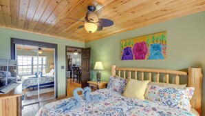 A spacious bedroom with a large bed, wooden ceiling, and a painting of bears on the wall. - Prime Views! Above & Beyond Pigeon Forge Cabin (Sevierville)