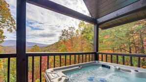 A hot tub on a wooden deck with a scenic view of autumn foliage and mountains. - Prime Views! Above & Beyond Pigeon Forge Cabin (Sevierville)