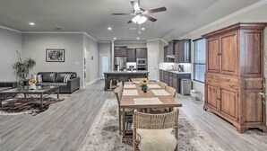A spacious living room with a dining area, a kitchen, and a large wooden cabinet. - Aledo Home: Covered Patio & Yard, Near Fort Worth! (Aledo)