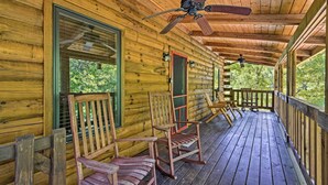 A wooden cabin with a porch, rocking chairs, and a ceiling fan. - Rustic Andrews Cabin Rental w/ Deck + Fire Pit! (Andrews)