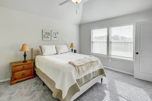A bedroom with a bed, two bedside tables, a ceiling fan, and a window with blinds. - Bastrop Home w/ Yard, 28 Mi to Austin! (Bastrop)