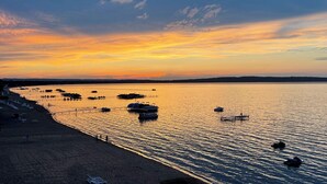 A beach with boats and a pier. - Beachfront Traverse City Resort Condo w/ Pool (Traverse City)