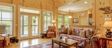 A spacious living room with a large sofa, a coffee table, and a patterned rug.