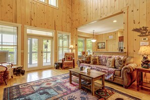 A spacious living room with a large sofa, a coffee table, and a patterned rug. - Hot Tub & Mtn Views: Beautiful Bryson City Home (Bryson City)