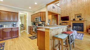 Una cocina amplia con armarios de madera, una isla central y una chimenea.