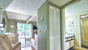 A living room with a sofa, a dining table, and a kitchen area with a sink and cabinets. - Branson Escape: 9 Mi to Silver Dollar City! (Branson)