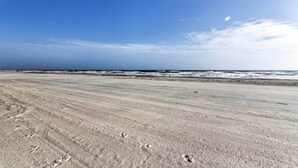 A wide sandy beach with footprints and a clear view of the ocean. - Beachfront Retreat: 16 Mi to Dtwn Freeport! (Freeport)