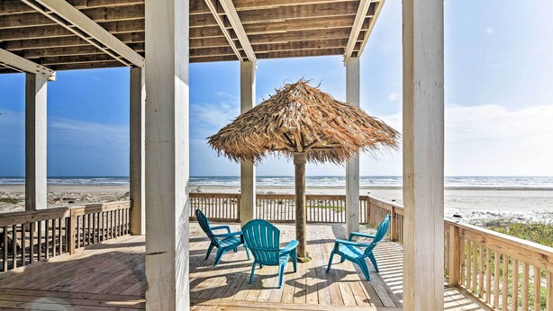 A wooden deck with a thatched umbrella, two chairs, and a view of the beach. - Beachfront Retreat: 16 Mi to Dtwn Freeport! (Freeport)