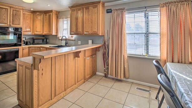 A kitchen with wooden cabinets, a built-in microwave, and a sink. - Central Hot Springs Family Home w/ Deck! (Hot Springs)