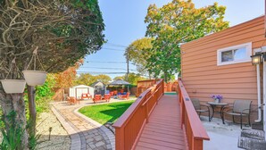 A patio area with outdoor furniture, a wooden deck, and a small garden. - Central Elmont Studio w/ Great Outdoor Space! (Elmont)