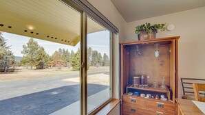 A room with a large sliding glass door leading to a driveway, a wooden cabinet with drawers, and a potted plant on top. - Charming Cle Elum Home w/ Patio: 5 Mi to Dtwn! (Cle Elum)