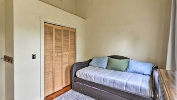 A bedroom with a bed, a wooden closet, and a patterned rug.