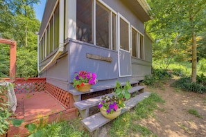 A cabin with a porch, wooden benches, and potted plants. - Charming Rusk Guest Cabin w/ Shared Yard (Rusk)