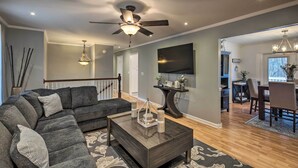 A modern living room with a sectional sofa, a coffee table, and a ceiling fan. - Chattanooga House Rental w/ Private Backyard! (Chattanooga)