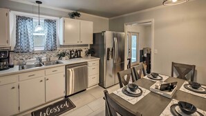 A modern kitchen with stainless steel appliances, a dining area with marble tableware, and a sign that reads "blessed". - Chattanooga House Rental w/ Private Backyard! (Chattanooga)