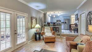 A spacious living room with a fireplace, a dining area, and a kitchen in the background. - Sunroom & Yard: Charming Hot Springs Home! (Hot Springs)