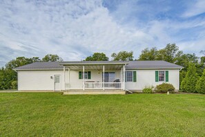 A two-story house with a front porch, a covered patio, and a well-maintained lawn. - Charming Lewisburg Home w/ Hot Tub & Games! (Lewisburg)