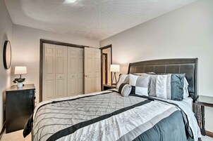 Quarto com uma cama grande, duas mesas de cabeceira, um guarda-roupa e um teto com design texturizado.