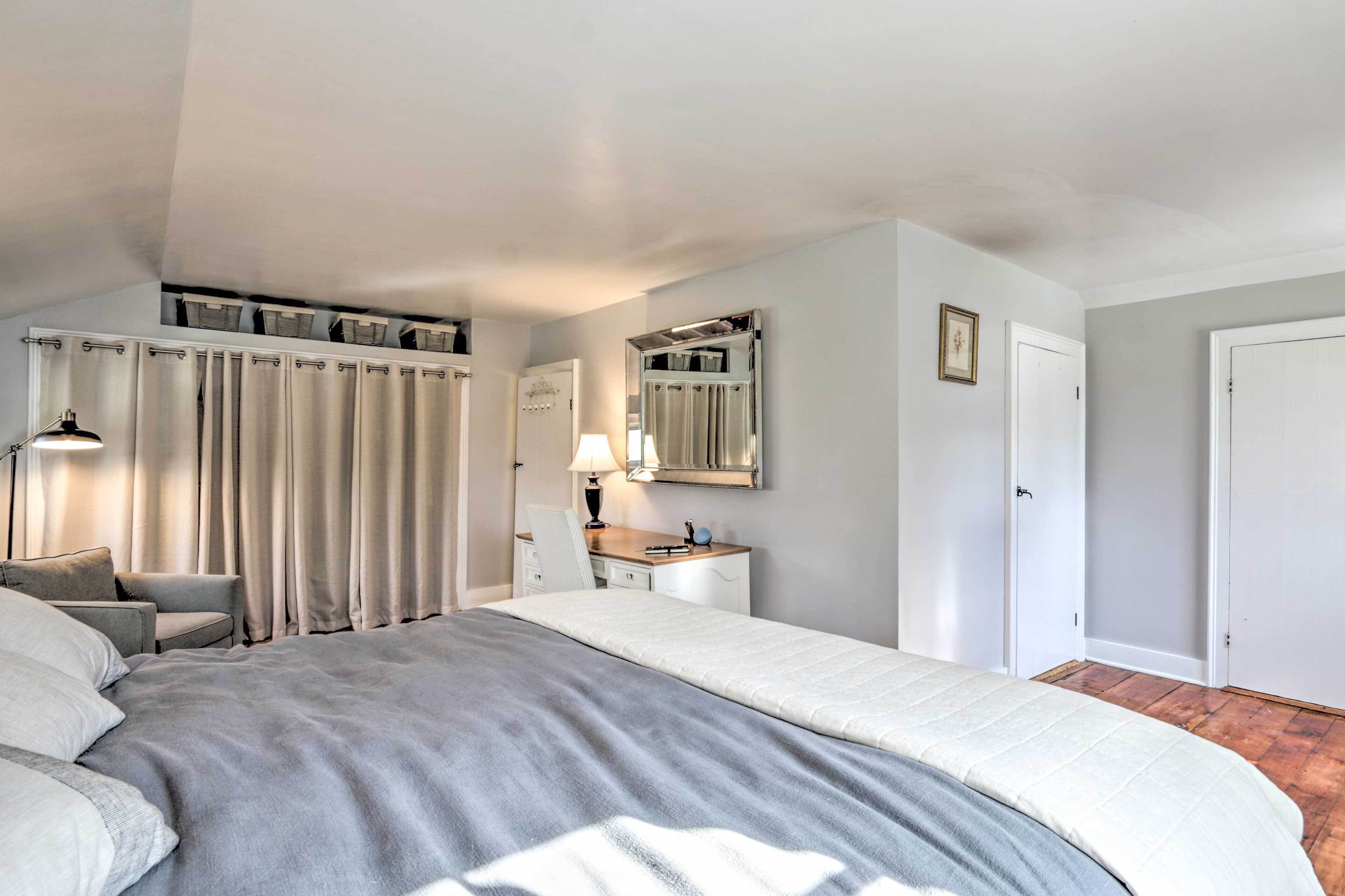 Une chambre à coucher avec un grand lit, un bureau, une chaise, une lampe et une armoire.
