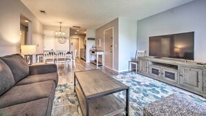A modern living room with a sofa, coffee table, and TV stand. - Cozy Condo w/ Pool Access in the Heart of Branson! (Branson)