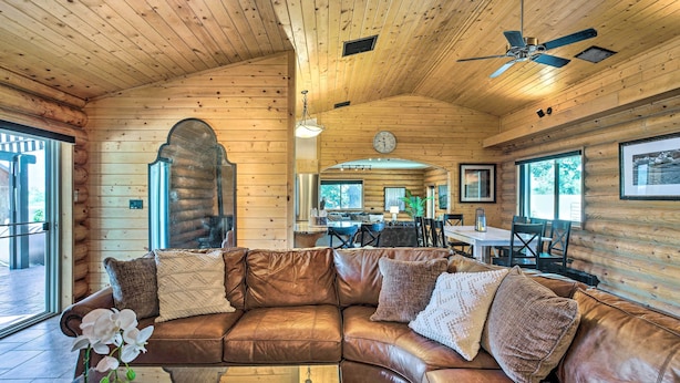 A cozy cabin interior with a leather sofa, wooden walls, and a dining area. - 'ali River Farms' Breathtaking Mt Backdrop! (Clifton)