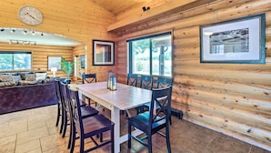 A log cabin interior with a dining area, a sofa, and a clock on the wall. - 'ali River Farms' Breathtaking Mt Backdrop! (Clifton)