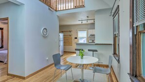 A modern kitchen with a dining area, wooden flooring, and a view of the living room. - < 3 Mi to Dtwn: Cleveland Apt w/ Deck & Wet Bar (Cleveland)