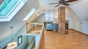 A spacious loft with a high ceiling, skylight, and a brick fireplace. - < 3 Mi to Dtwn: Cleveland Apt w/ Deck & Wet Bar (Cleveland)