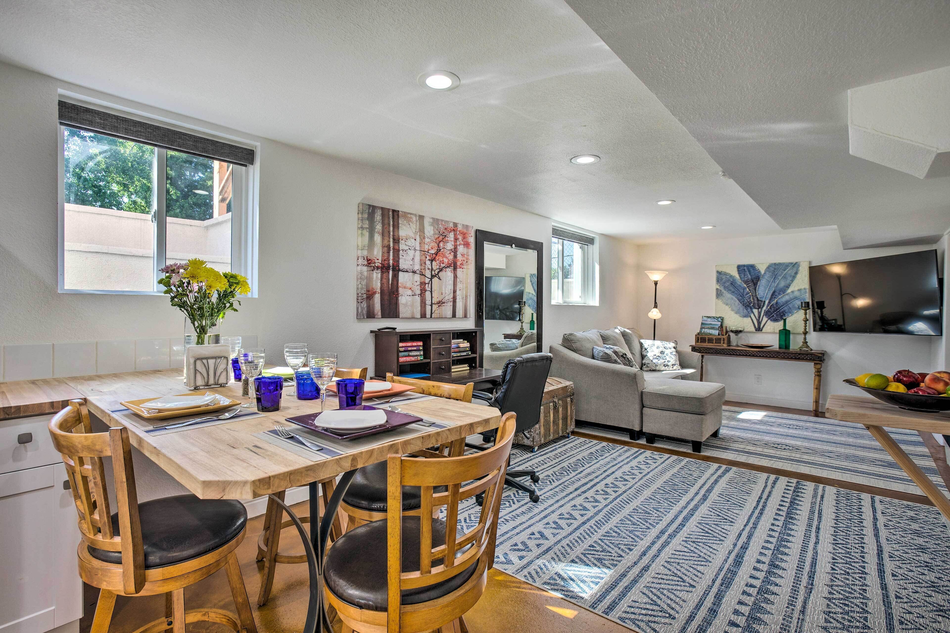 A modern living room with a dining area, a sofa, and a TV.