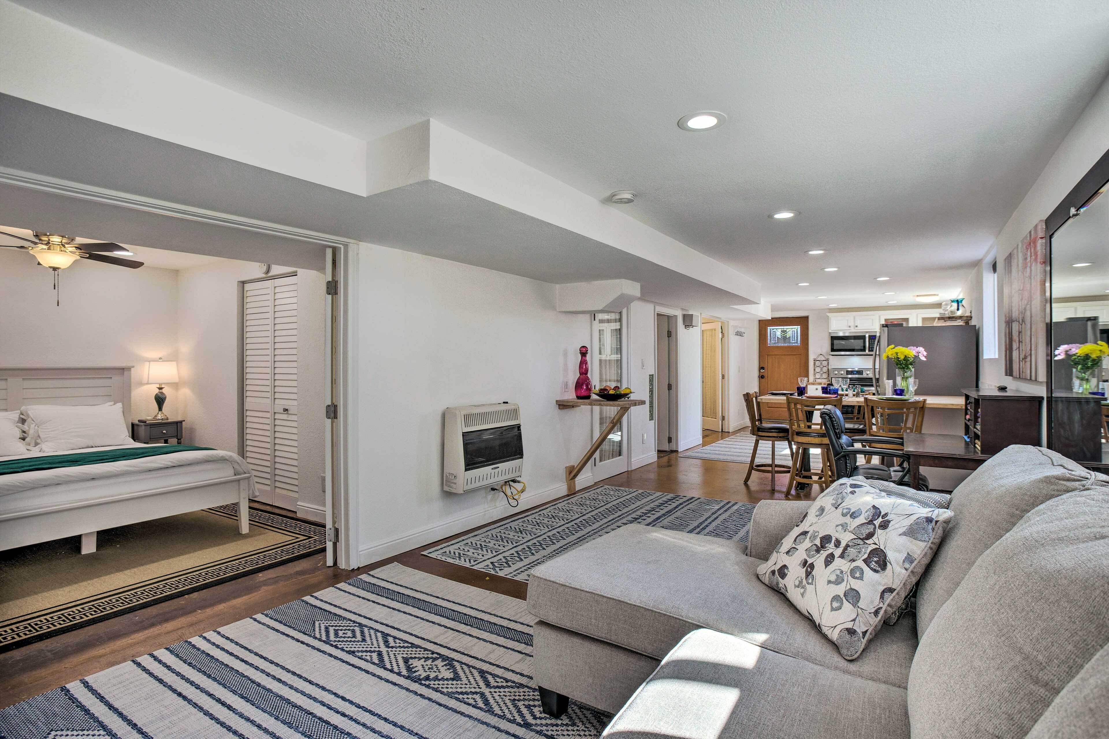 A modern living room with a sofa, a bed, and a dining area.