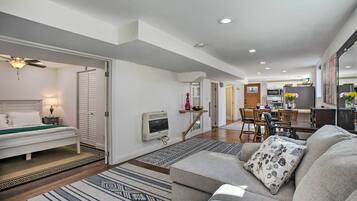 A modern living room with a sofa, a bed, and a dining area.
