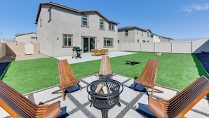 A modern two-story house with a patio area featuring a fire pit, lounge chairs, and a dining set. - Near Empire Polo Field: Coachella Vacation Rental (Coachella)