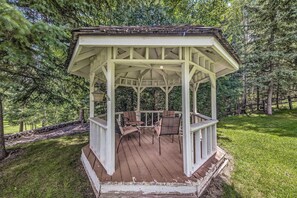 Un kiosque doté d’une terrasse en bois et de deux chaises.