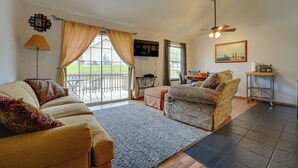A spacious living room with a sofa, armchair, and a dining area.