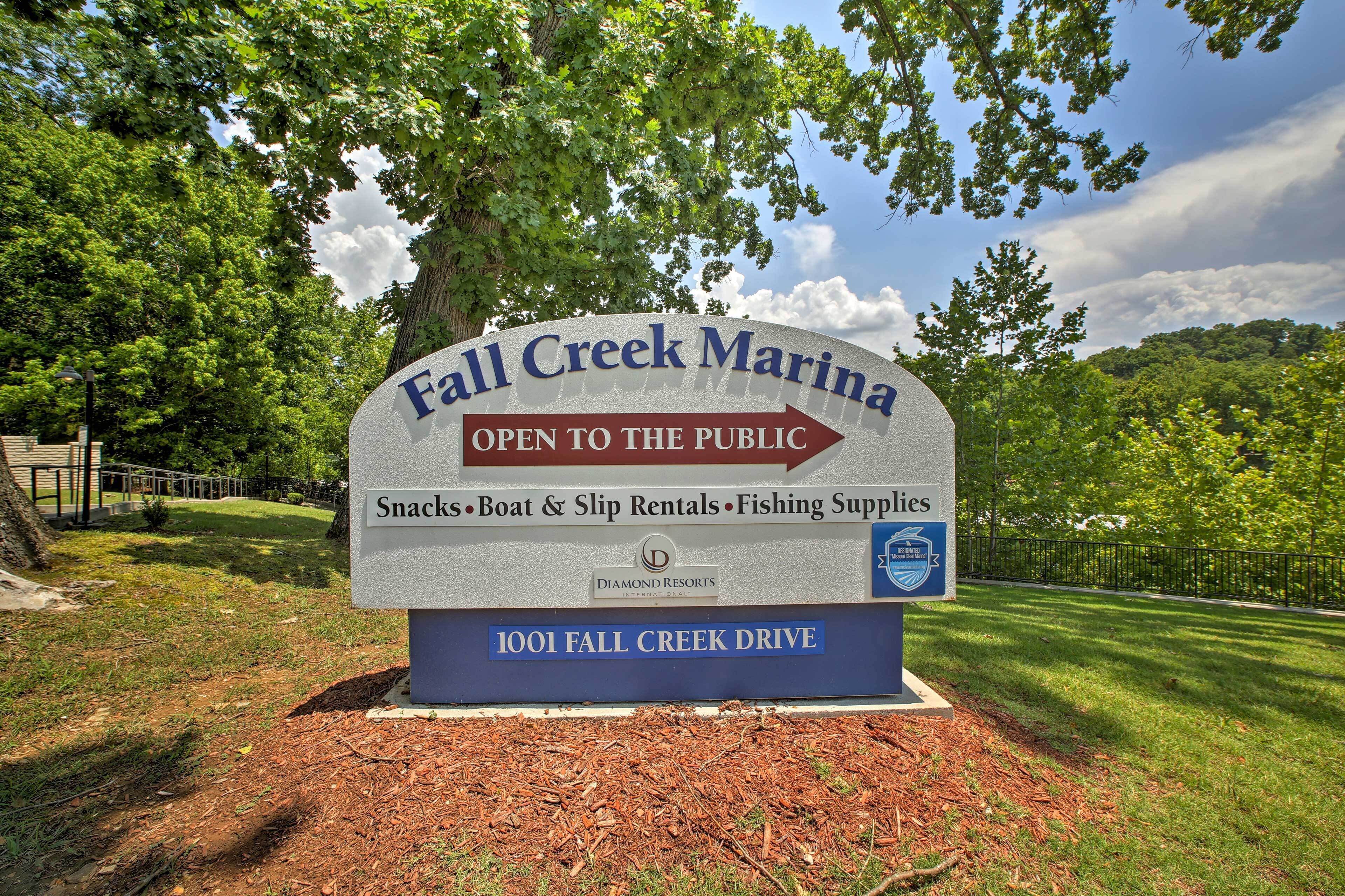 A sign for Fall Creek Marina, indicating it is open to the public and offers snacks, boat and slip rentals, and fishing supplies.