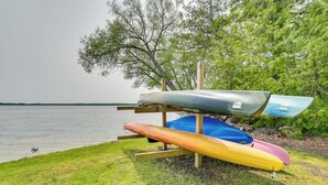A row of kayaks on a wooden stand by a lake. - Near Snowmobiling! Carp Lake Cottage w/ Fire Pit (Carp Lake)
