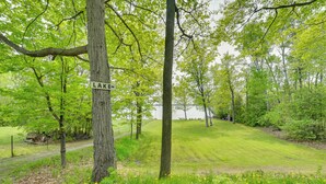 A park with a sign reading "LAKE" and a path leading to a body of water. - Near Snowmobiling! Carp Lake Cottage w/ Fire Pit (Carp Lake)