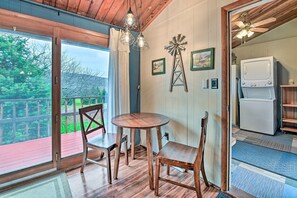 Un comedor de madera con una mesa y sillas, un ventilador de techo y vistas a una terraza.