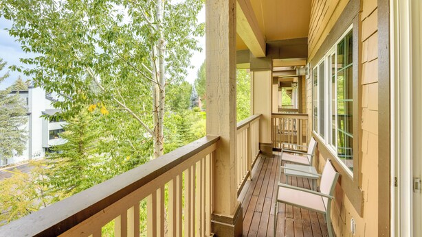 A wooden balcony with a railing, a wooden deck, and a view of trees and buildings. - Condo w/ Mtn View < 1 Mi to Steamboat Resort! (Steamboat Springs)