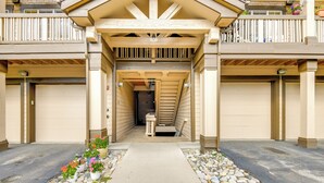 A building entrance with a covered walkway, stone pathway, and potted plants. - Condo w/ Mtn View < 1 Mi to Steamboat Resort! (Steamboat Springs)