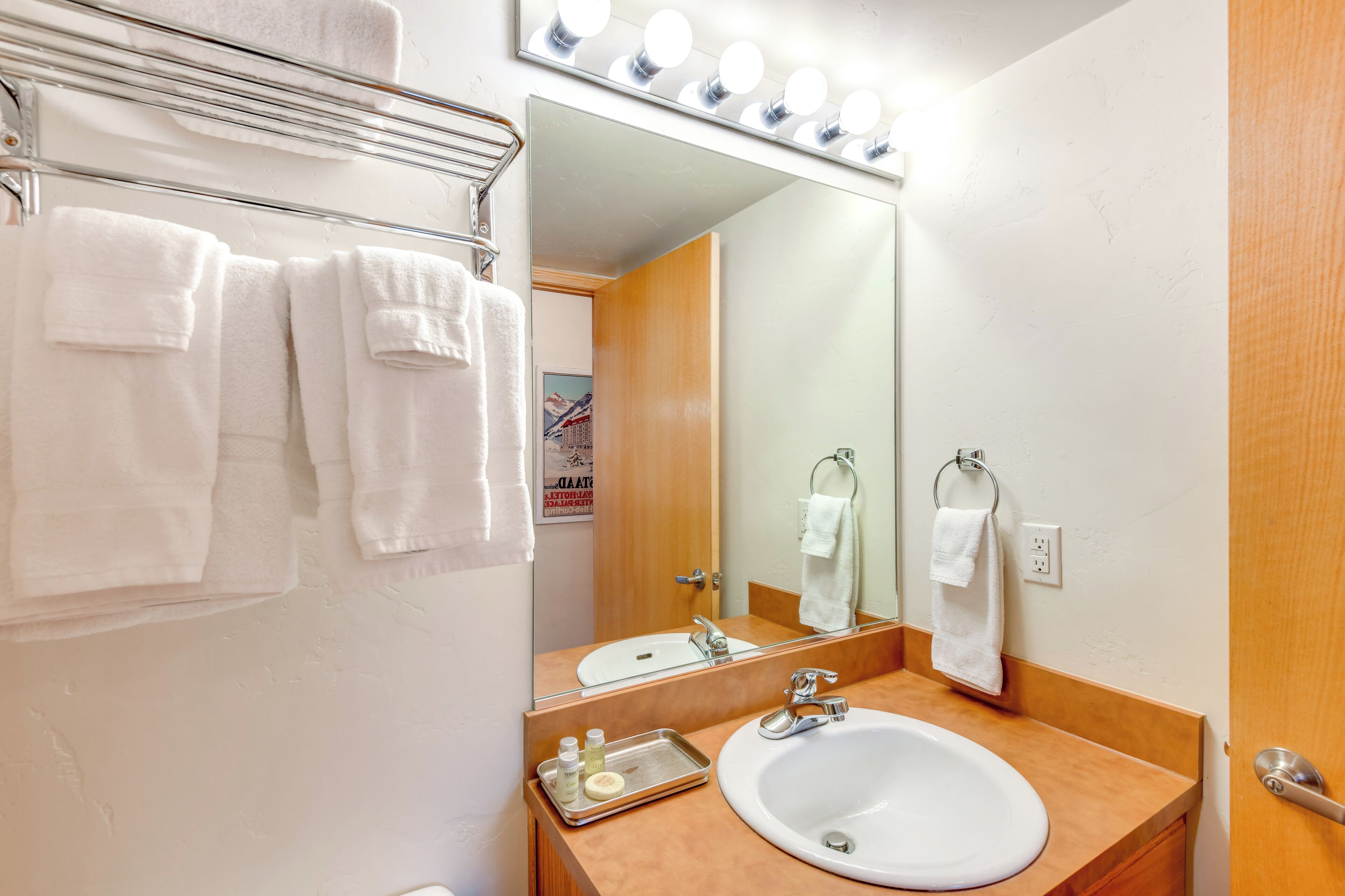 Une salle de bain équipée d’un lavabo, d ’un miroir et d’un porte-serviettes.
