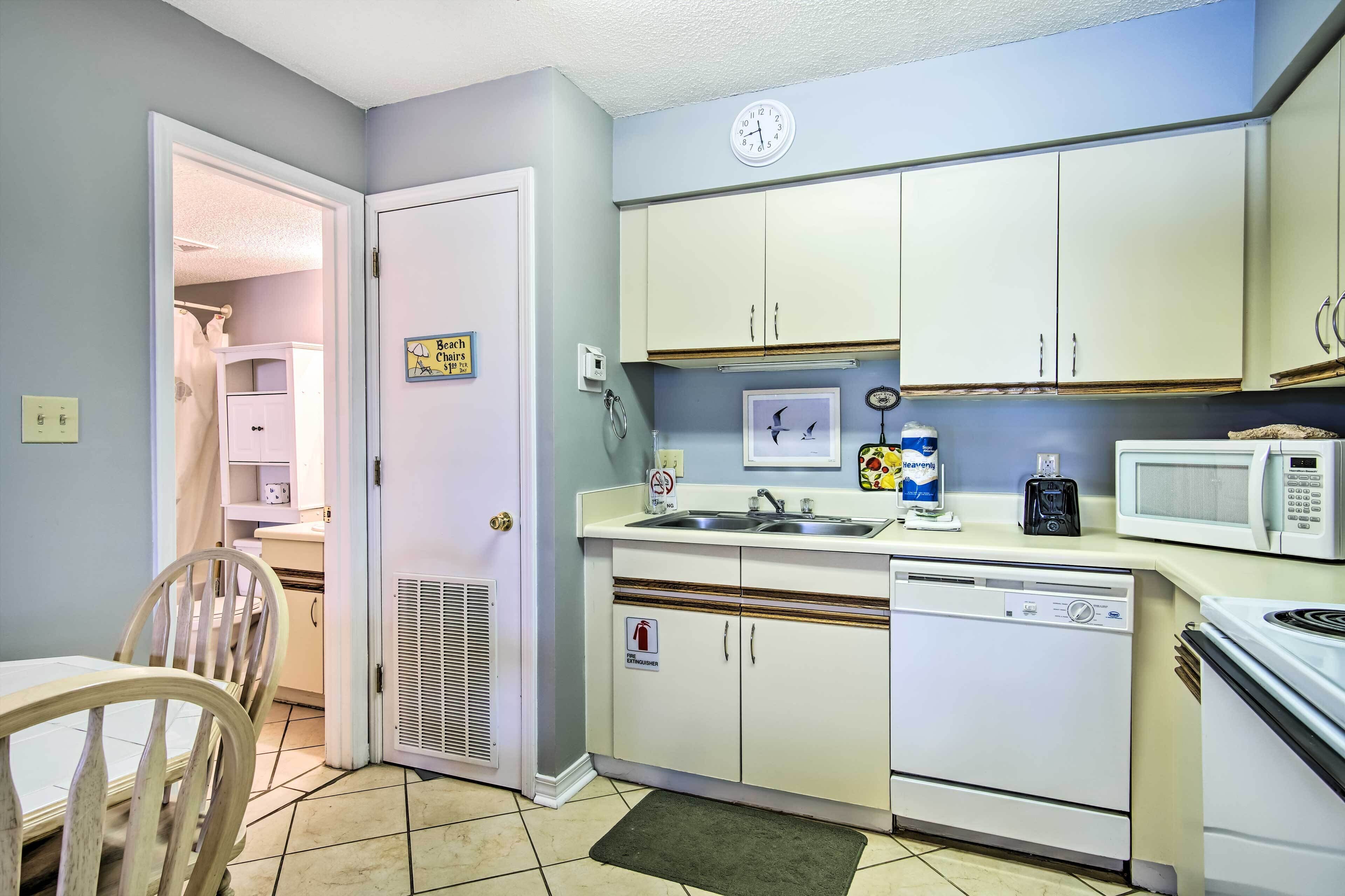 A compact kitchen with white cabinets, a microwave, a dishwasher, and a sink.