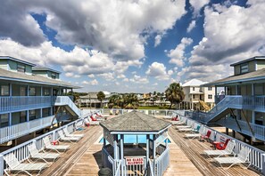 A beachside hotel with a pool deck, lounge chairs, and a 'No Glass Allowed' sign. - Gulf Shores Condo w/ Pool Access: Steps to Beach! (Gulf Shores)