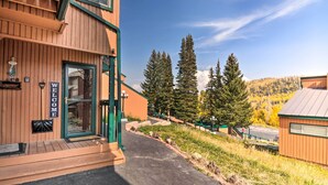 Un bâtiment en bois avec une pancarte indiquant « BIENVENUE », un chemin pavé et de grands arbres en arrière-plan.