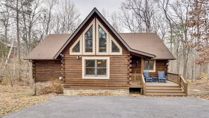 A log cabin with a large front window, a porch with blue chairs, and a stone foundation. - 1 Mi to Slopes! Family-friendly Massanutten Cabin (McGaheysville)