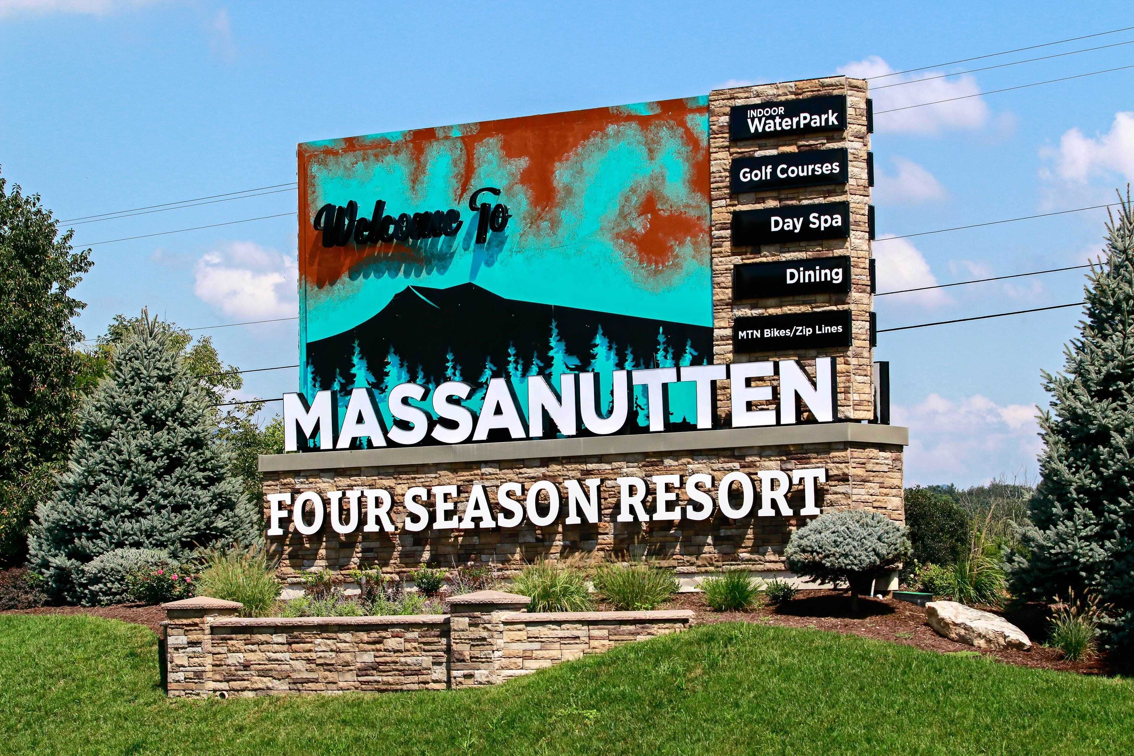 A billboard for Massanutten Four Season Resort with amenities including indoor waterpark, golf courses, day spa, dining, and mountain bikes/zip lines.