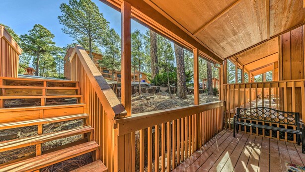 Eine Holzterrasse mit einer Bank und einer Treppe zu einem überdachten Bereich.