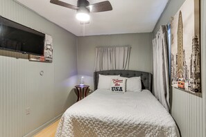 A bedroom with a bed, a ceiling fan, a nightstand with a lamp, and a wall clock. - Cozy Livingston House w/ Fenced Yard + Patio! (Livingston)