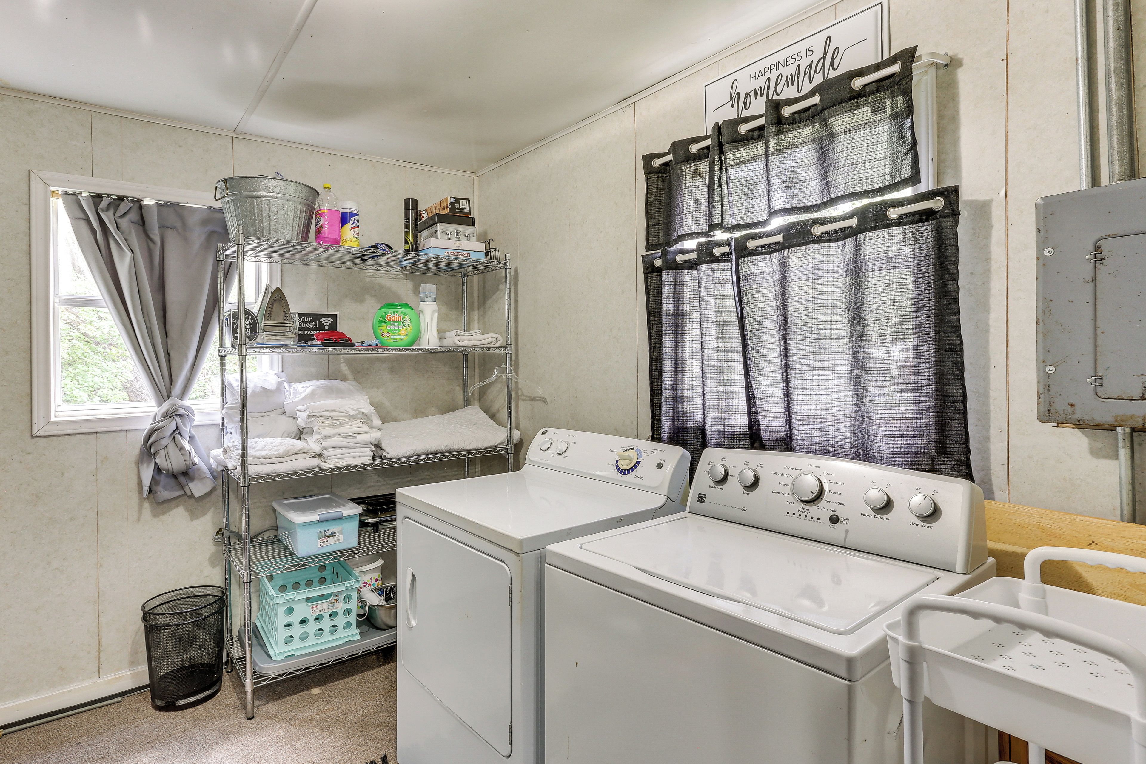 A laundry room with a washing machine, dryer, and shelves with cleaning supplies.